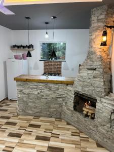 a stone fireplace in a kitchen with a counter and a bar at Catavento in Paty do Alferes