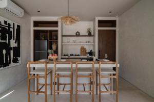 a kitchen with a island with bar stools at Heritage Villas in Uluwatu