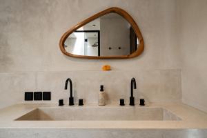 a bathroom with a sink and a mirror at Heritage Villas in Uluwatu +16 photos