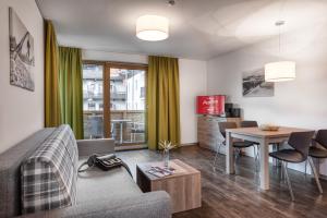 a living room with a couch and a table at AlpenParks Hotel & Apartment Orgler Kaprun in Kaprun