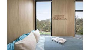 a bedroom with a bed with two towels on it at Churinga Orchards by Tiny Away in Lenswood