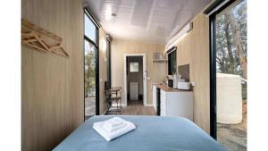 a bedroom with a blue bed and a kitchen with a counter at Churinga Orchards by Tiny Away in Lenswood +11 photos