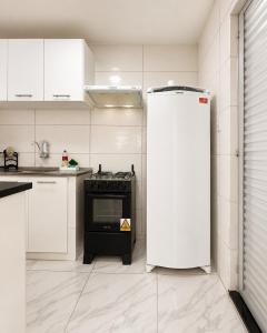a kitchen with a refrigerator and a stove at AmazHost - Casa Rosa com Split, Wi-Fi 700 Mb e Água Quente in Belém