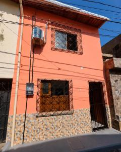 a pink house with a window and a fence at AmazHost - Casa Rosa com Split, Wi-Fi 700 Mb e Água Quente in Belém