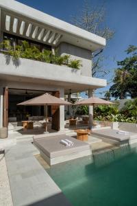 a house with a swimming pool with umbrellas at Heritage Villas in Uluwatu