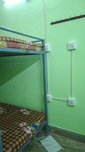 a bunk bed in a room with green walls at Atithi Stay in Bhubaneshwar +1 photo