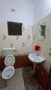 a bathroom with a toilet and a sink at Atithi Stay in Bhubaneshwar