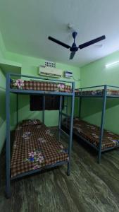 two bunk beds in a room with a ceiling fan at Atithi Stay in Bhubaneshwar