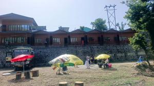 a group of people with umbrellas in front of a building at trigun pahadi hub in Uttarkāshi