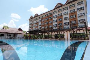 a hotel with a large swimming pool in front of a building at Permai Hotel Kuala Terengganu in Kuala Terengganu