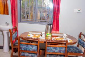 a dining room table with chairs and a sink at Kasese Explorers Homestay in Kasese