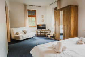 a bedroom with two beds and a living room at Hotel Růžové údolí in Pivonín