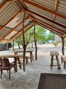 a group of picnic tables and benches under a pavilion at Wana beach camp in Raddela