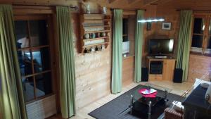 ein Wohnzimmer mit Holzwänden und einem TV in der Unterkunft Ferienwohnung Elisabeth in Weyarn
