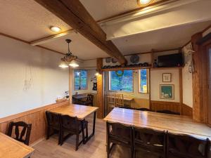 a dining room with wooden tables and chairs at Koguma no ie in Nozawa Onsen