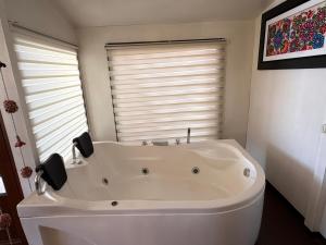 a white bath tub in a bathroom with a window at Titicaca Samca Lodge Puno Peru in Puno