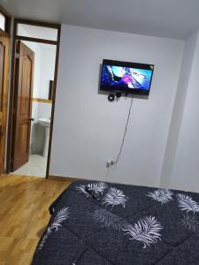 a bedroom with a flat screen tv on the wall at Hostal jm in Huancayo +10 photos