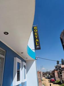 a sign on the side of a building with a surfboard at Hostal jm in Huancayo