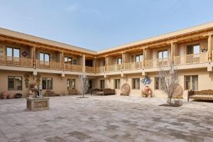 a courtyard of a building with benches and tables at Arda Karvon Saroy in Khiva