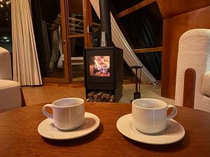 two cups of coffee sitting on a table in front of a fireplace at Titicaca Samca Lodge Puno Peru in Puno +40 photos