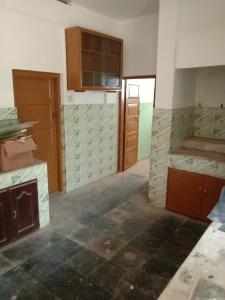 an empty kitchen with wooden cabinets in a room at Kailas in Kollam