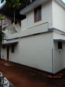 a white building with a large garage at Kailas in Kollam