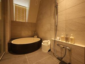 a bathroom with a bath tub and a shower at 友愛ファームゲストハウス in Hatoyama