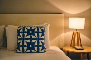 a bed with a blue and white pillow and a lamp at Healesville Hotel in Healesville