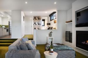 a living room with a couch and a fireplace at Saltus One bedroom- luxury and panoramic views in Hepburn Springs