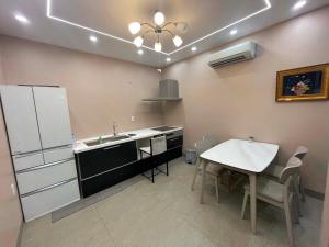 a kitchen with a sink and a table and a refrigerator at Nâu Homestay in Hai Phong