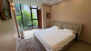 a bedroom with a bed and a large window at Nâu Homestay in Hai Phong