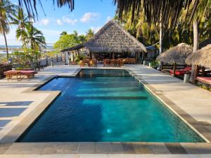 a pool at a resort with a beach in the background at Belar Reef Bungalows in Nembrala