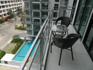 - un balcon avec deux chaises et une table dans un bâtiment dans l'établissement Neo Condo by Jean, à Jomtien Beach