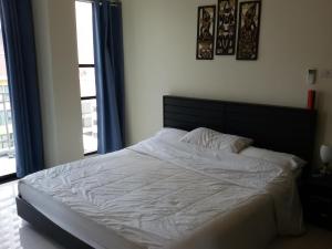 a bedroom with a white bed with a large window at Neo Condo by Jean in Jomtien Beach