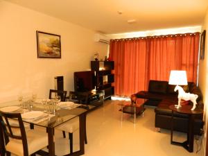 a living room with a dining table and a living room with a couch at Neo Condo by Jean in Jomtien Beach