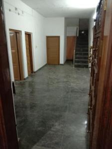 an empty hallway with stairs and a room with concrete floors at Kailas in Kollam