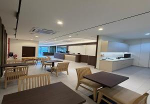 a dining room with tables and chairs and a kitchen at Coastline Hotel 6 Avenue PortDickson in Port Dickson