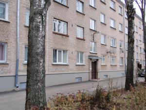 un edificio de ladrillo con ventanas blancas y una puerta en Central Cietokšņa Street Apartment, en Daugavpils
