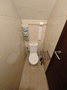 a small bathroom with a toilet and towels at Flo's Transit Home in Manado +19 photos
