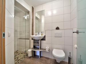 a white bathroom with a sink and a toilet at Appartement Haus Tanja in Haus im Ennstal