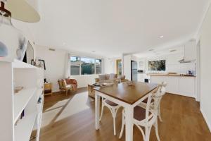 a kitchen and living room with a wooden table and chairs at Charming Guesthouse in Kyneton in Kyneton