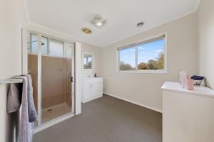 a white bathroom with a shower and a window at Charming Guesthouse in Kyneton in Kyneton +7 photos