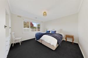 a white bedroom with a bed and a window at Charming Guesthouse in Kyneton in Kyneton