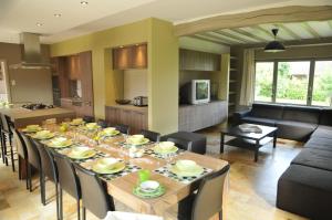 Chez Ines في Marloie: غرفة طعام وغرفة معيشة مع طاولة وكراسي