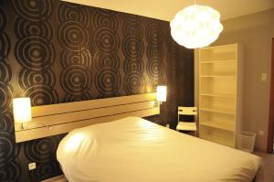 een slaapkamer met een wit bed en een zwarte muur bij Chez Ines in Marloie