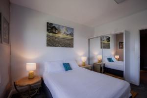 a bedroom with two beds and two lamps in it at Ruby SoHo Spa Villa in Port Sorell