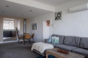 a living room with a gray couch and a table at Ruby SoHo Spa Villa in Port Sorell