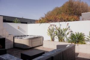 a patio with a hot tub on a white wall at Ruby SoHo Spa Villa in Port Sorell