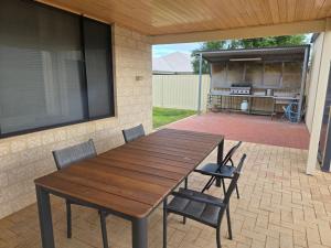 a wooden table and chairs on a patio at Maniki Gardens, 9 Maniki Gardens in Jurien Bay