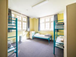 a room with two bunk beds and a window at YHA Newcastle Beach in Newcastle